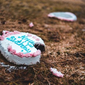Sad birthday cake on the ground